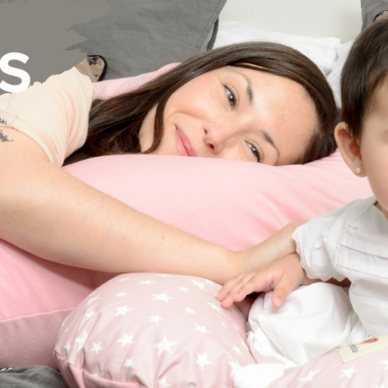 Madre e hija descansan sobre cojines suaves de Amamantas, ideales para maternidad y bebés.