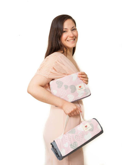 Mujer sonriente sosteniendo la Manta de Picnic y Playa Impermeable Extra Grande Rosa de Amamantas, ideal para momentos al aire libre.