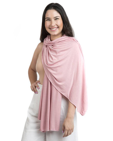 Mujer sonriente usando pañuelo de lactancia 6 en 1 color palo rosa, hecho de algodón suave y orgánico.