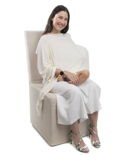Mujer sentada usando un pañuelo de lactancia crudo de algodón, cubriendo suavemente mientras amamanta. Ideal para comodidad y estilo.