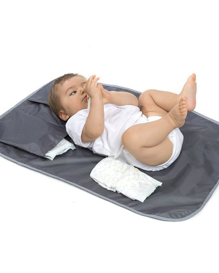Bebé sobre mudador portátil y neceser impermeable grafito de Amamantas, ideal para cambiar pañales.